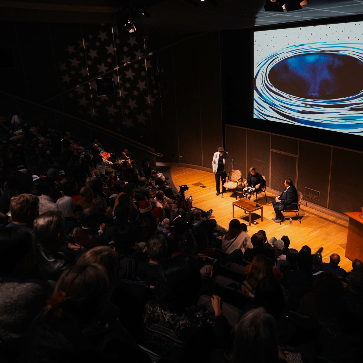 A full auditorium watches special guests at All Space Considered.