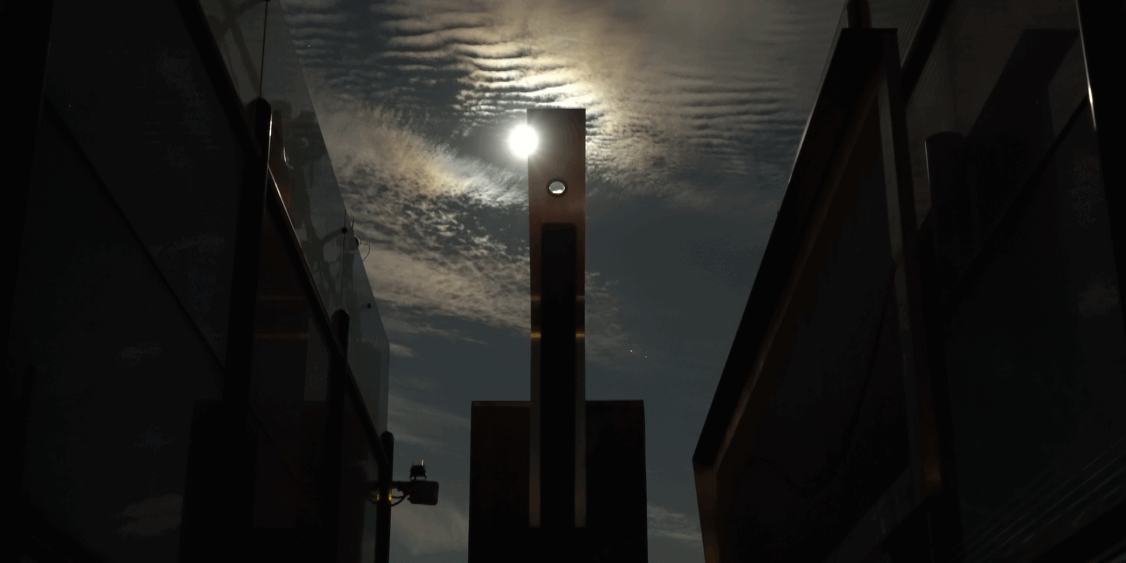The moon crossing over the aluminum monolith.